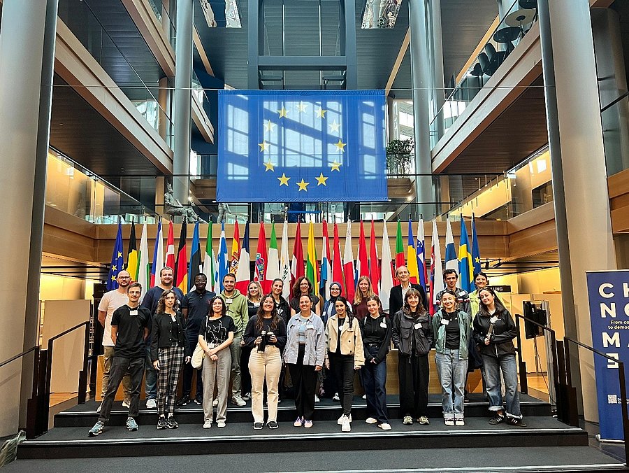 Die Teilnehmer:innen der Strassburg-Exkursion im Europäischen Parlament, vor den Flaggen der Staaten der Europäischen Union
